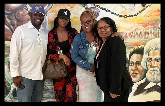  4 volunteers from spirit and truth church standing in front of CAY mural